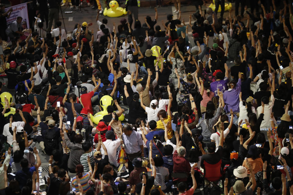 A crowd of protesters flash three-finger protest gestures during a rally Friday, Nov. 27, 2020 in Bangkok, Thailand. Pro-democracy demonstrators are continuing their protests calling for the government to step down and reforms to the constitution and the monarchy, despite legal charges being filed against them and the possibility of violence from their opponents or a military crackdown. (AP Photo/Sakchai Lalit)