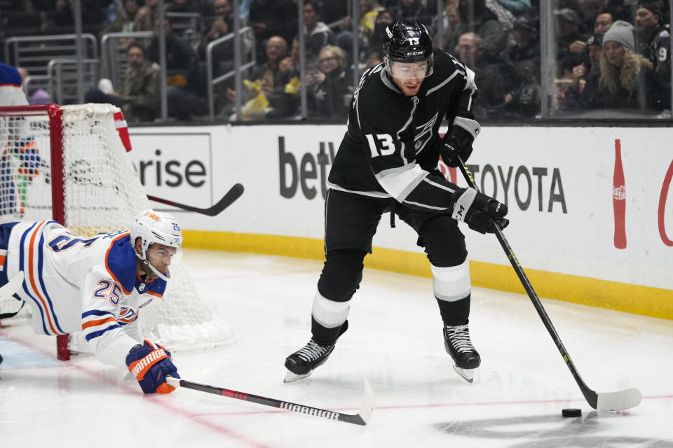 Los Angeles Kings' Gabriel Vilardi (13) moves the puck away from Edmonton Oilers' Darnell Nurse (25) during the second period of an NHL hockey game Monday, Jan. 9, 2023, in Los Angeles. (AP Photo/Jae C. Hong)