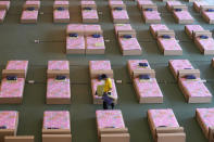 A volunteer walks past a 1,800-bed field hospital set up inside a cargo building in Don Mueang International Airport in Bangkok, Thailand, Thursday, July 29, 2021. Health authorities raced on Thursday to set up yet another large field hospital in Thailand's capital as the country recorded a new high in COVID-19 cases and deaths. The hospital, one of many already in use, was being set up at one of Bangkok's two international airports after the capital ran out of hospital beds for thousands of infected residents. (AP Photo/Sakchai Lalit)