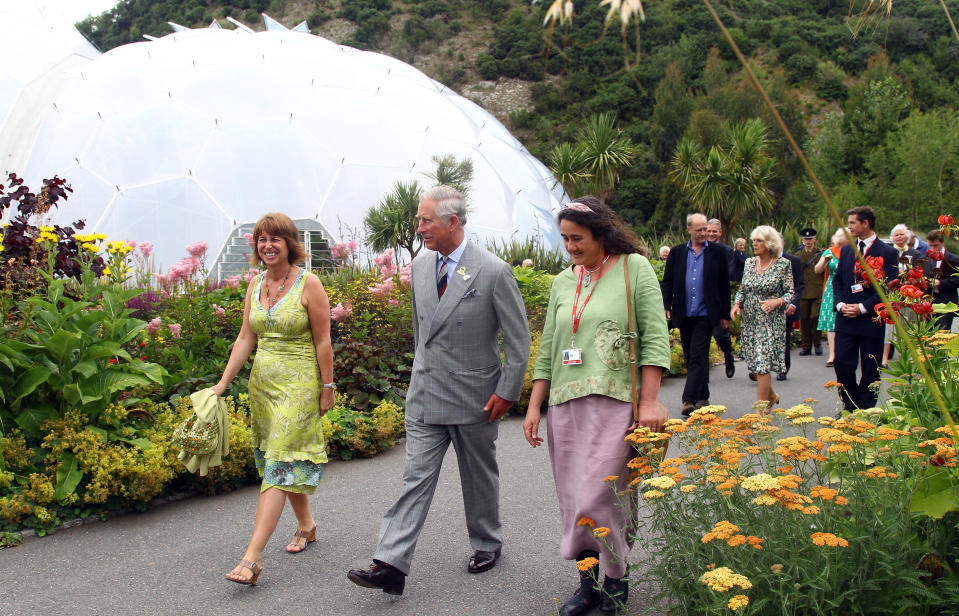 ST AUSTELL, ENGLAND - JULY 12:  Gaynor Coley, Managing Director of Eden (L) walks with Prince Charles, Prince of Wales as they leave the Mediterranean biome as he visits the Eden Project on July 12, 2011 in St Austell, England.  The visit coincides as Eden celebrates its 10th birthday. The Eden Project in Cornwall, which opened in 2001 and has attracted over ten million visitors, showcases 100,000 plants from around the world in two giant transparent domes, each recreating different climate conditions. Both domes are made of hexagons of tough plastic with the first dome emulating a tropical environment, the second a warm Mediterranean environment.  (Photo by Matt Cardy - WPA Pool/Getty Images)