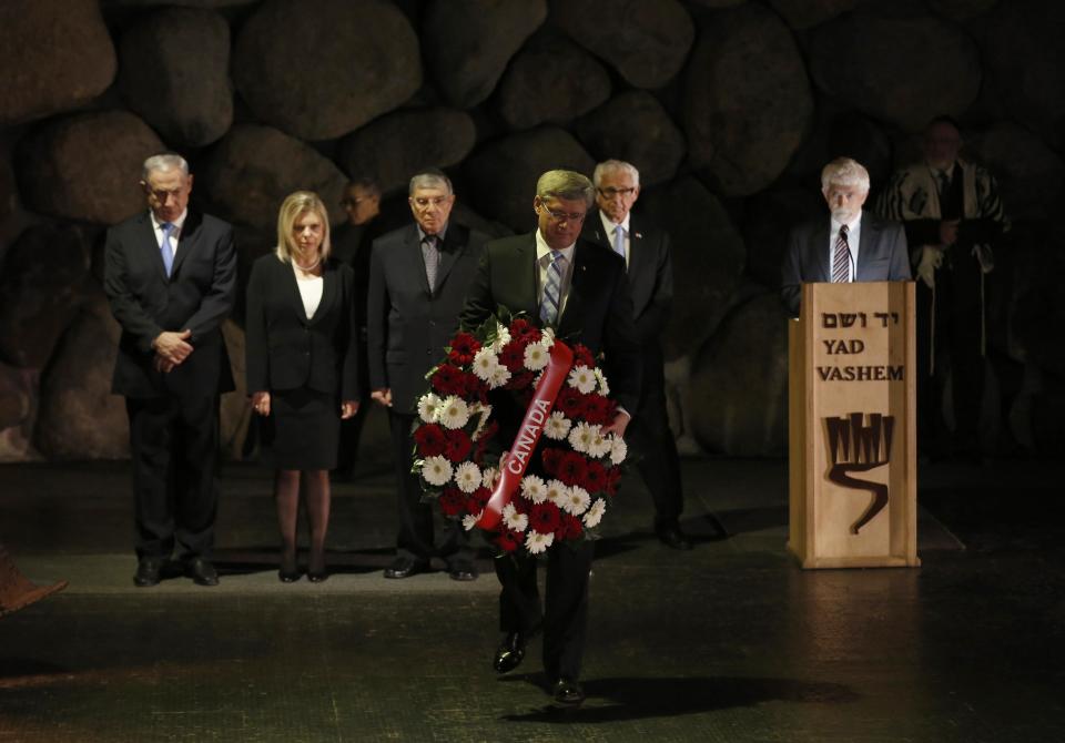 Canada's Prime Minister Stephen Harper lays a wreath during a ceremony in the Hall of Remembrance at the Yad Vashem Holocaust memorial in Jerusalem January 21, 2014. Harper told Israel's parliament on Monday any comparison between the Jewish state and apartheid South Africa was "sickening", drawing a standing ovation - and an angry walkout by two Arab legislators. REUTERS/Baz Ratner (JERUSALEM - Tags: POLITICS)