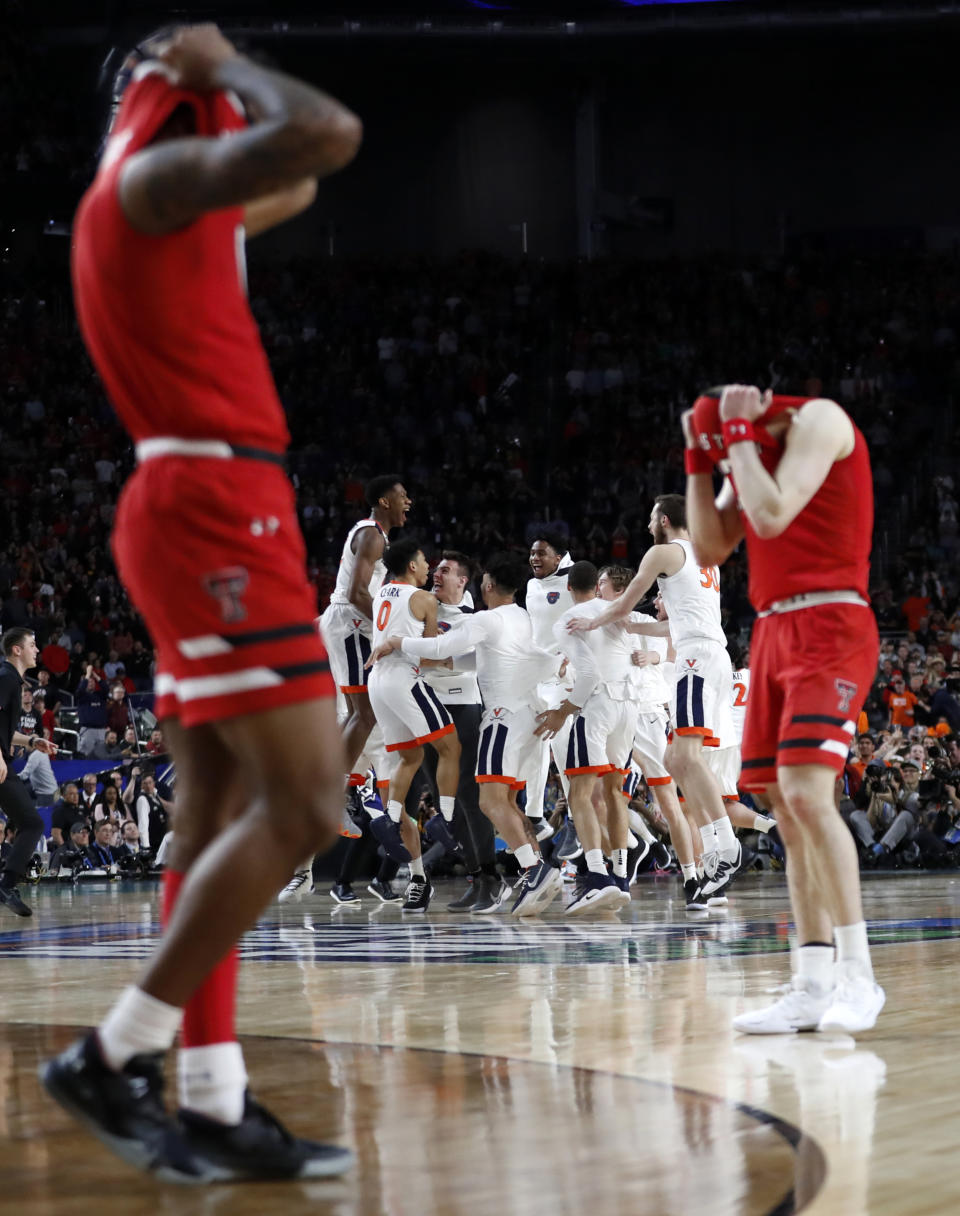 FILE - Texas Tech, foreground, and Virginia players react after Virginia beat Texas Tech 85-77 in overtime in the championship of the Final Four NCAA college basketball tournament, April 8, 2019, in Minneapolis. (AP Photo/Jeff Roberson, File)