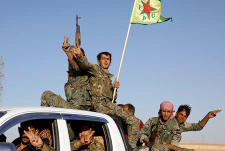 Fighters of Syrian Democratic Forces make the V-sign as their convoy passes in Ain Issa, Syria October 16, 2017. REUTERS/Erik De Castro