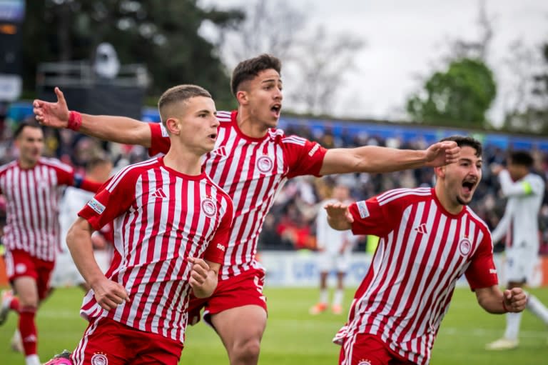 El volante griego de Olympiakos Christos Mouzakitis (izq.) celebra junto a sus compañeros el primer gol en la final de la UEFA Youth League contra el AC Milan, en Nyon (Suiza), el 22 de abril de 2024 (Fabrice Coffrini)