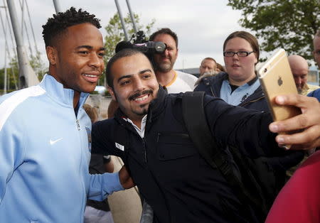 New Manchester City signing Raheem Sterling poses for photographs with supporters as he leaves the club's Etihad Stadium in Manchester, Britain, July 14, 2015. REUTERS/Andrew Yates