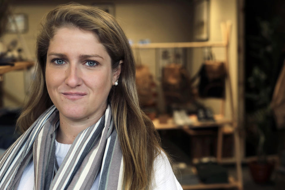 In this Thursday, Nov. 14, 2019, photo, Annie Venditti, vice president of operations at clothing retailer American Rhino, stands for a photograph in the store, in Faneuil Hall Marketplace, in Boston. At the age of 23, Venditti was learning about the complexities of building and liquor laws. The company did the smart thing, and got a consultant to guide them. (AP Photo/Steven Senne)