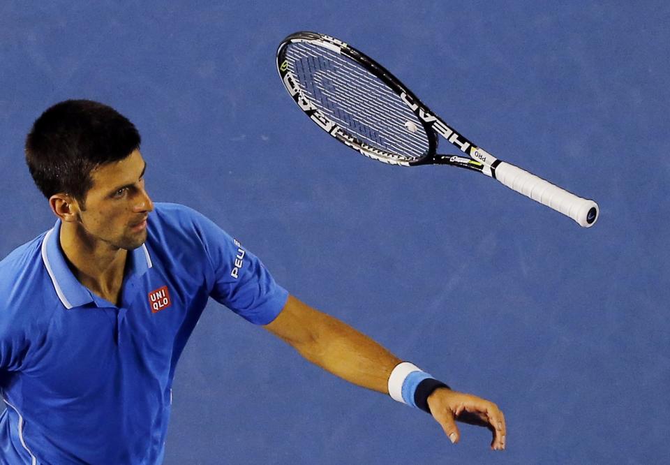 Novak Djokovic of Serbia throws his racket after missing a return to Stan Wawrinka of Switzerland during their men's singles semi-final match at the Australian Open 2015 tennis tournament in Melbourne January 30, 2015. REUTERS/Carlos Barria (AUSTRALIA - Tags: SPORT TENNIS)