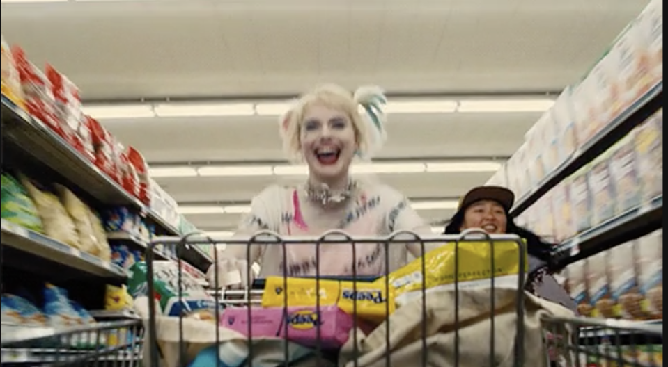 a woman running with a shopping cart in a grocery store