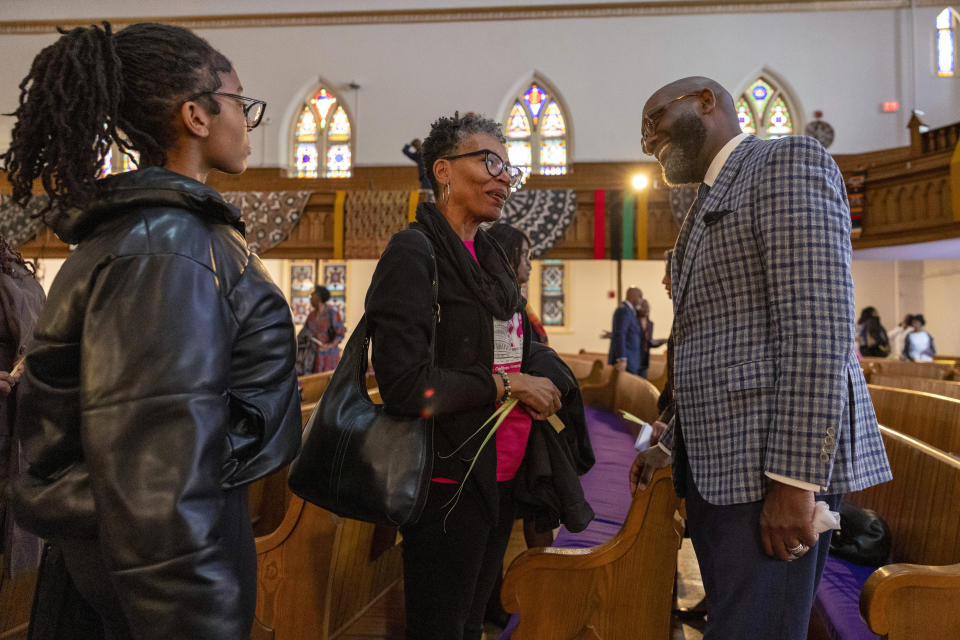 Rev. William H. Lamar IV, right, talks to Karla Bruce-Choice and her daughter Lilia Choice, 14, following Palm Sunday services at the Metropolitan AME Church in Washington, Sunday, March 24, 2024. Lamar says their churches are still feeling the pandemic’s impact on attendance, even as they have rolled out robust online worship options to reach people. (AP Photo/Amanda Andrade-Rhoades)