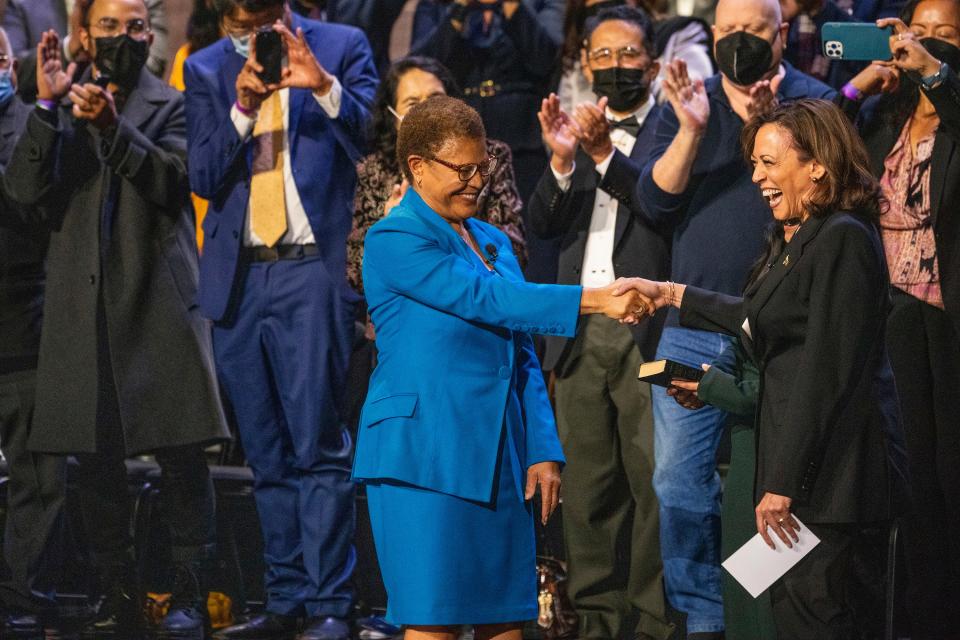 Karen Bass, the first Black woman elected Los Angeles mayor, left, shakes hands with Vice President Kamala Harris, a longtime friend, and former California attorney general in Los Angeles, at Bass' swearing-in ceremony on Sunday.