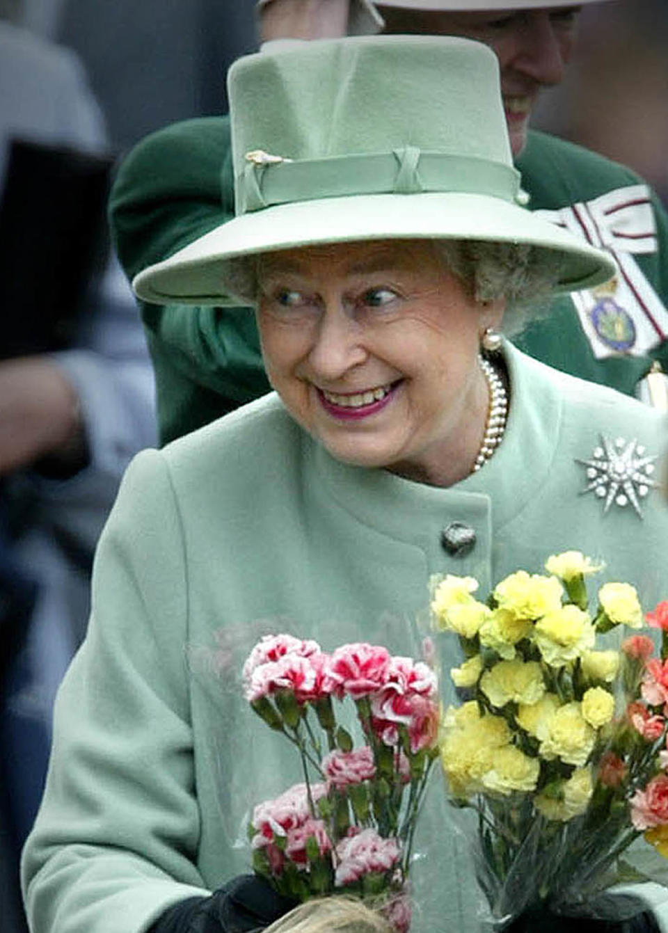 Britain's Queen Elizabeth shows her delight as she is presented with
flowers from children during her walkabout on Melrose Market square in
the Scottish Borders May 29, 2002. REUTERS/Jeff J Mitchell

JJM/PS