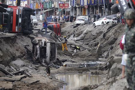 Rescue personnel survey the wreckage after an explosion in Kaohsiung, southern Taiwan, August 1, 2014. REUTERS/Toby Chang