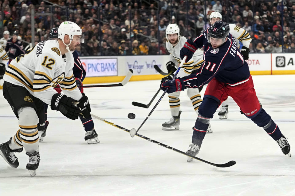 Columbus Blue Jackets center Adam Fantilli (11) shoots in front of Boston Bruins defenseman Kevin Shattenkirk (12) in the second period of an NHL hockey game Tuesday, Jan. 2, 2024, in Columbus, Ohio. (AP Photo/Sue Ogrocki)