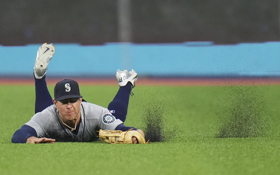 Seattle Mariners right fielder Dylan Moore (25) makes a diving catch to out Toronto Blue Jays left fielder Raimel Tapia during the fourth inning of a baseball game in Toronto, Monday, May 16, 2022. (Nathan Denette/The Canadian Press via AP)