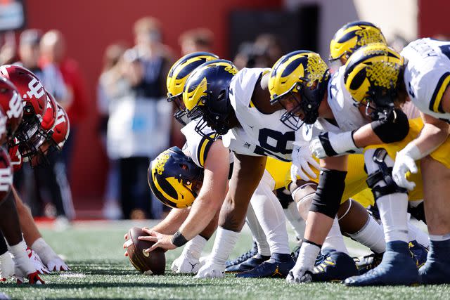 <p>Icon Sportswire via AP</p> Michigan Wolverines players line up at the line of scrimmage