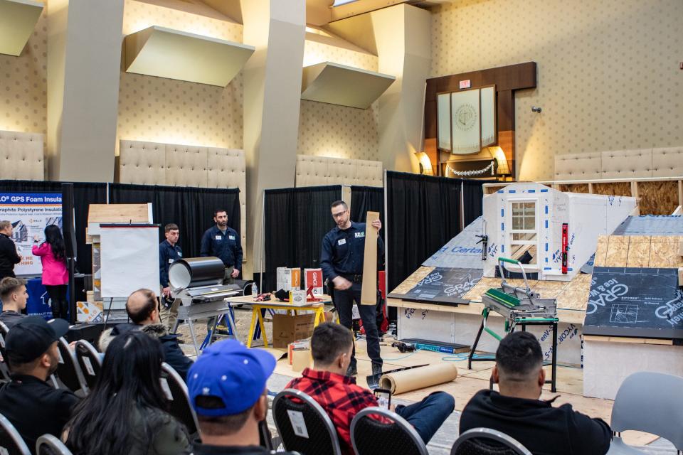 A builder holds a piece of lumber during a demonstration at the JLC Live Residential Construction Show in Providence on Saturday.