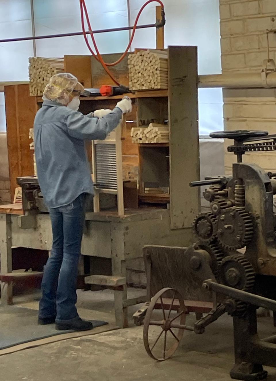 Workers at the Columbus Washboard Co. use modern tools as well as antique equipment to hand-assemble the washboards.