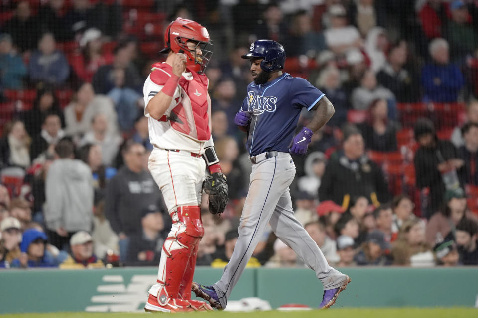 Tampa Bay Rays' Randy Arozarena, right, scores in front of Boston Red Sox's Reese McGuire, left, on a single by Isaac Paredes in the ninth inning of a baseball game, Thursday, May 16, 2024, in Boston. (AP Photo/Steven Senne)