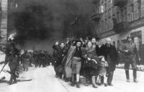 FILE - In this 1943 file photo, a group of Polish Jews are led away for deportation by German SS soldiers during the destruction of the Warsaw Ghetto by German troops after an uprising in the Jewish quarter.hetto by German soldiers on April 19, 1943. This year, as the world commemorates the 77th anniversary of the liberation of the German Nazi Auschwitz concentration and extermination camp on January 27, 1945, Yad Vashem and the Conference on Jewish Material Claims against Germany have teamed up to highlight the stories of "Righteous Rescuers" the people who risked everything, even their own lives, to save Jews from getting murdered by the Nazis and their henchmen. (AP Photo, file)