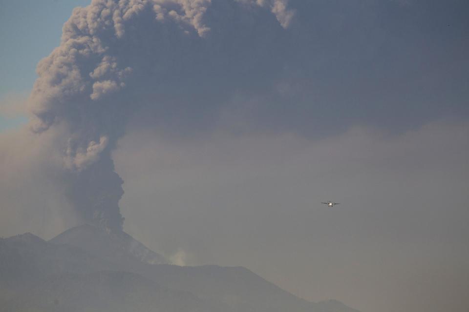 A light aircraft flies towards La Aurora airport in Guatemala City as the Pacaya Volcano spews ash, Sunday, March 2, 2014. column of ash rises from the Pacaya volcano as seen from Villa Nueva, Guatemala, Sunday, March 2, 2014. Guatemala authorities say the Pacaya volcano near Guatemala City has shot plumes of ash and vapor 2.3 miles (3.7 kilometers) high, while spewing glowing-hot rock. The eruption early Sunday is the latest round of activity at the scenic volcano located just 30 miles (50 kms) south of Guatemala City. (AP Photo/Moises Castillo)