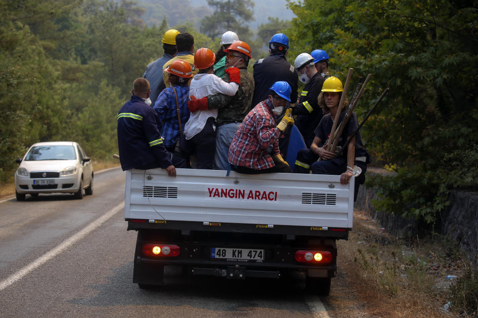 Turkish volunteers head to fight wildfires in Turgut village, near tourist resort of Marmaris, Mugla, Turkey, Wednesday, Aug. 4, 2021. As Turkish fire crews pressed ahead Tuesday with their weeklong battle against blazes tearing through forests and villages on the country's southern coast, President Recep Tayyip Erdogan's government faced increased criticism over its apparent poor response and inadequate preparedness for large-scale wildfires.(AP Photo/Emre Tazegul)