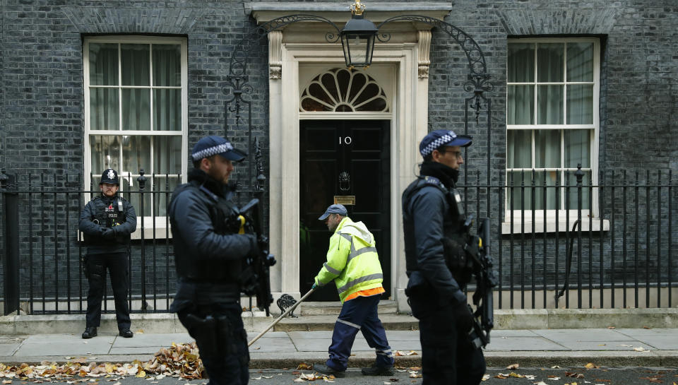 A street cleaner clears autumn leaves from the front of 10 Downing Street, in London, Wednesday, Nov. 6, 2019. Britain goes to the polls on Dec. 12. (AP Photo/Alastair Grant)