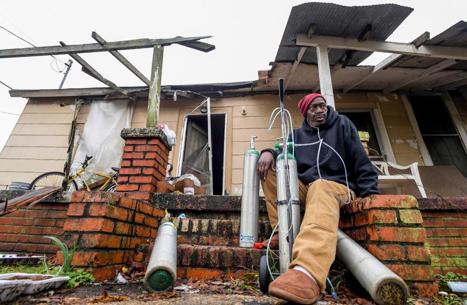 Rodney Harris sits with his oxygen talks on the front steps at his storm damaged home after overnight fatal storms hit the Lower Wetumpka Road area in Montgomery, Ala., on Wednesday morning November 30, 2022. 