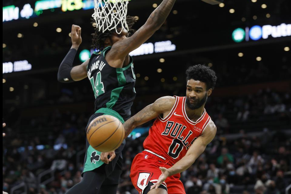 Chicago Bulls' Coby White (0) passes off under the net against Boston Celtics' Robert Williams III (44) during the first half of an NBA basketball game, Saturday, Jan. 15, 2022, in Boston. (AP Photo/Michael Dwyer)