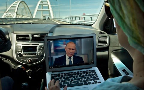 Russians watch Mr Putin's question-and-answer session while driving over a new bridge to Crimea, which was covered at length during the show - Credit: Sergei Malgavko/TASS via Getty Images