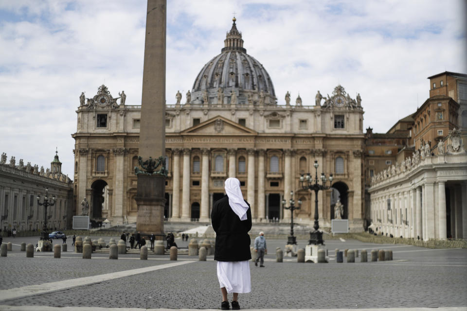 FILE - In this Sunday, March 21, 2021 filer, a nun stands in St. Peter's Square at the Vatican. Vatican prosecutors have alleged a jaw-dropping series of scandals in launching the biggest criminal trial in the Vatican’s modern history, which opens Tuesday in a modified courtroom in the Vatican Museums. The once-powerful cardinal and nine other people are accused of bleeding the Holy See of tens of millions of dollars in donations through bad investments, deals with shady money managers and apparent favors to friends and family. (AP Photo/Gregorio Borgia, File)