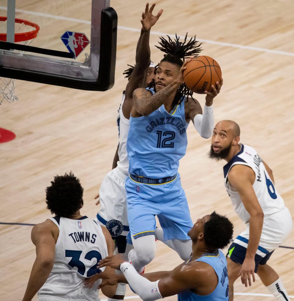 Memphis Grizzlies guard Ja Morant (12) shoots the ball while Minnesota Timberwolves guard Patrick Beverley (22) attempts to block him from behind during the first half of game four of the first round for the 2022 NBA playoffs on Saturday, April 23, 2022, at Target Center in Minneapolis, Minn.