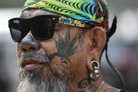A Thai activist with a marijuana tattoo on his face gathers with others during a campaign for the legalisation of medical marijuana near Government House in Bangkok, Thailand, November 20, 2018. REUTERS/Panumas Sanguanwong
