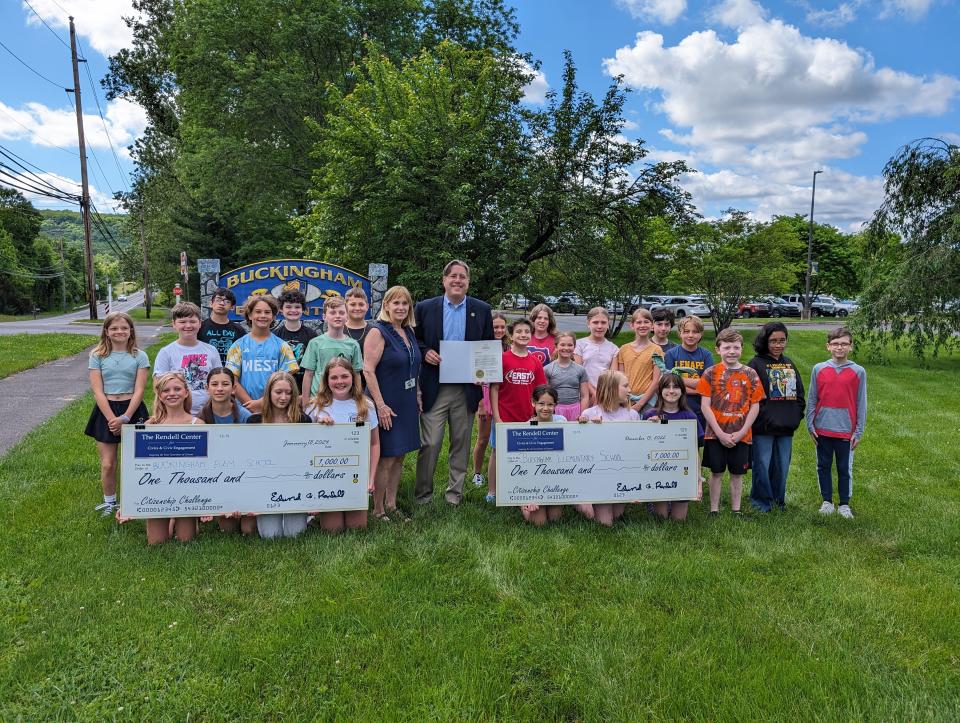 State Representative Tim Brennan, Linda Raitt Monkoski and her fifth grade class pose with two of their $1,000 prize checks and the proclamation from Governor Shapiro congratulating the Buckingham Elementary School team.