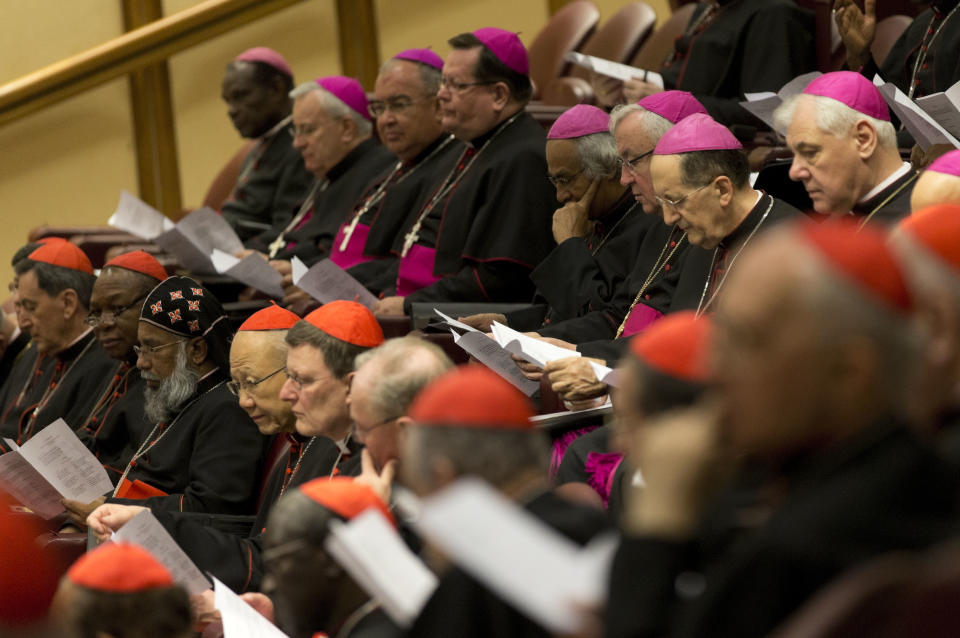 Bishops, wearing purple skull caps, who will be elevated to cardinals in a ceremony Saturday, attend an extraordinary consistory in the Synod hall at the Vatican City, Thursday, Feb. 20, 2014. Pope Francis opened the two-day meeting by urging his cardinals to find "intelligent, courageous" ways to help families under threat today without delving into case-by-case options to get around Catholic doctrine. He said the church must find ways to help families with pastoral care that is "full of love." (AP Photo/Alessandra Tarantino)