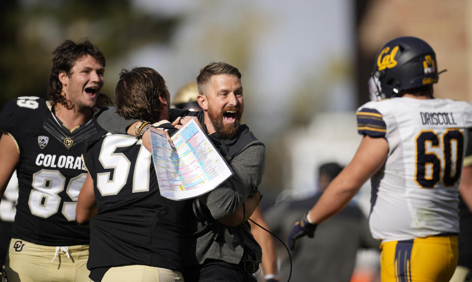 Colorado interim head coach Mike Sanford, third from left, celebrates with linebacker Thomas Notarianni, second from left, and tight end Louis Passarello, left, as California offensive lineman Brian Driscoll, right, walks off the field after overtime in an NCAA college football game in at Folsom Field, Saturday, Oct. 15, 2022, in Boulder, Colo. (AP Photo/David Zalubowski)