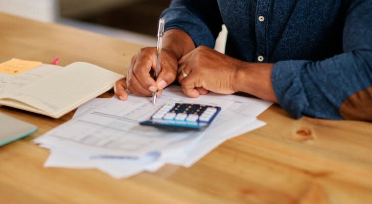 Image shows a senior man managing his investments. A financial advisor may assist him.