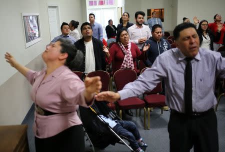 Honduran migrants Raul Contreras, his mother Daysi Alas (C) and step-father Ananin Cruz, who are seeking refugee status in Canada, attend a church service held in Spanish in Toronto, Ontario, Canada April 8, 2017. REUTERS/Chris Helgren