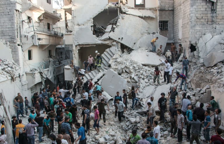 People gather at the scene after an air raid on Aleppo, in May 2015