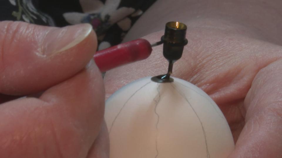 Reinders uses a kistka to plug the hole on the bottom of the chicken egg, where it was emptied. The hole has to be plugged before the egg is dipped in the dye bath to prevent it from filling.