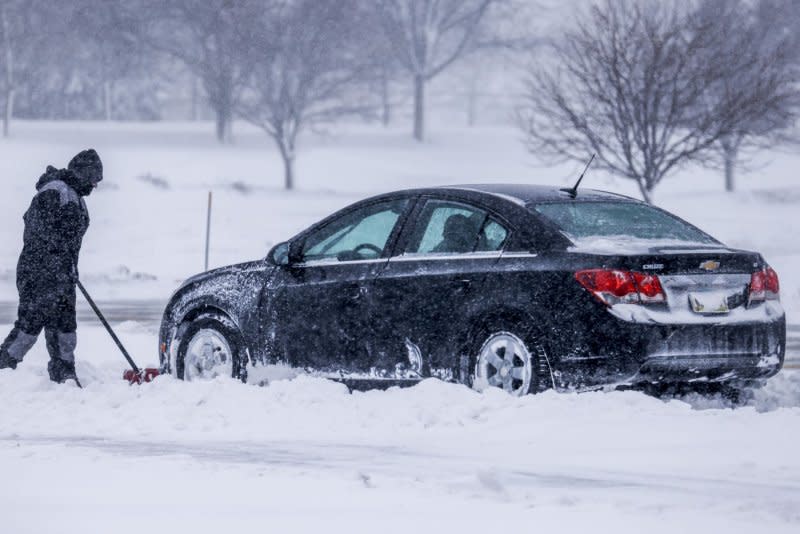 A man shovels snow away from a stuck vehicle as a winter storm hits in Altoona, Iowa, on Friday. The Midwest is expected to get 6 to 12 inches of snow through Saturday. Photo by Tannen Maury/UPI