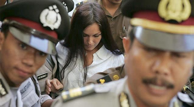 Police escort Corby through a throng during her trial. Photo: AAP