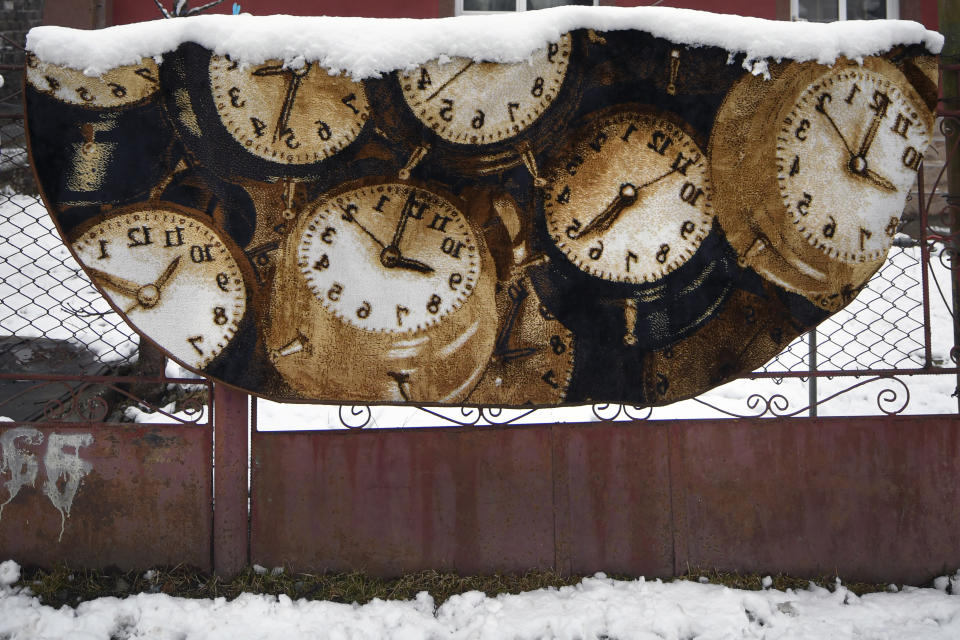 A blanket is coated in snow as it hangs on a fence to dry in Leresti, Romania, Saturday, Jan. 9, 2021. Valeriu Nicolae and his team visited villages at the foot of the Carpathian mountains, northwest of Bucharest, to deliver aid. The rights activist has earned praise for his tireless campaign to change for the better the lives of the Balkan country’s poorest and underprivileged residents, particularly the children. (AP Photo/Andreea Alexandru)