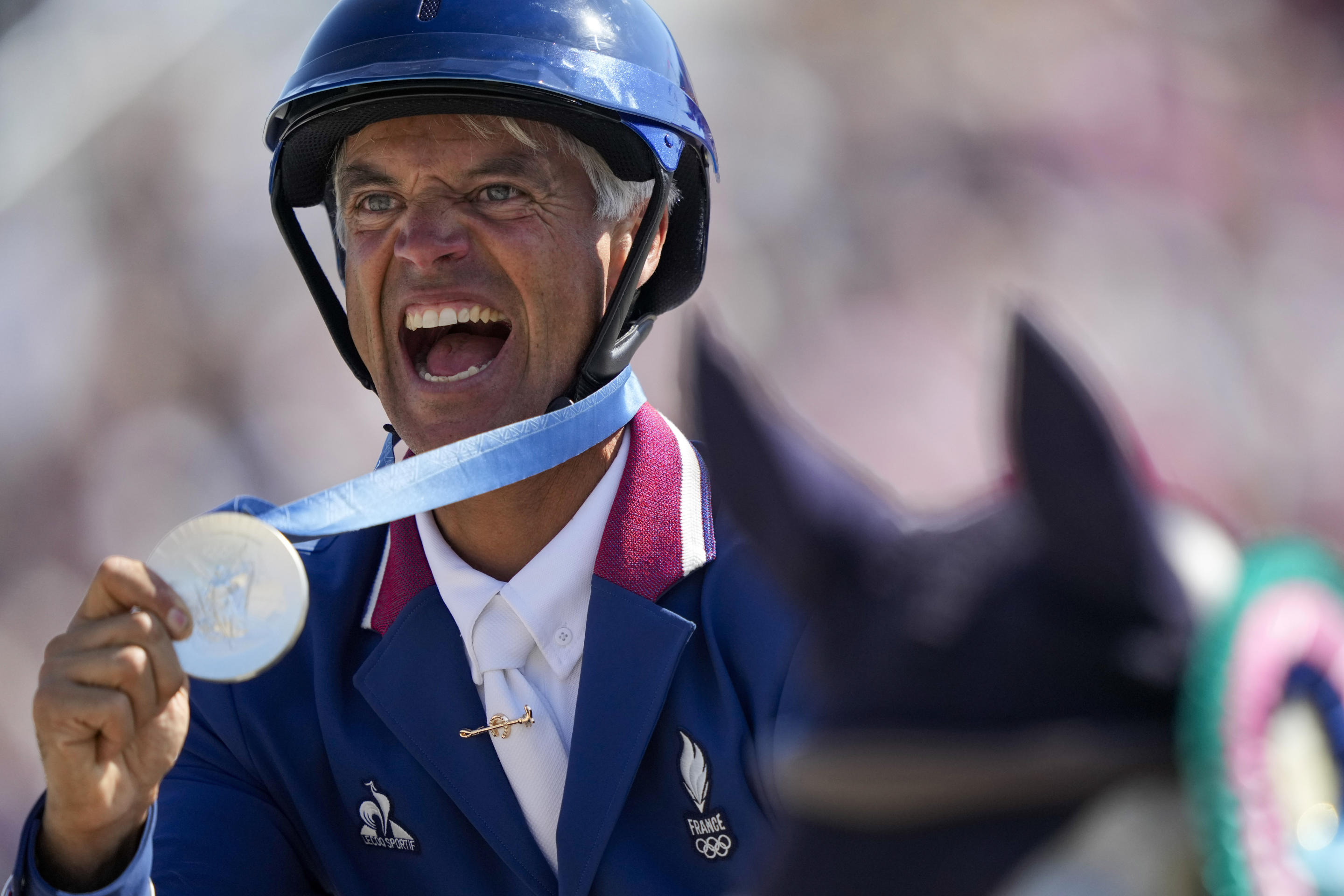 Karim Laghouag of France celebrates after winning the silver medal in the equestrian team jumping competition at the 2024 Summer Olympics on, July 29, 2024, in Versailles, France. (Mosa'ab Elshamy/AP)