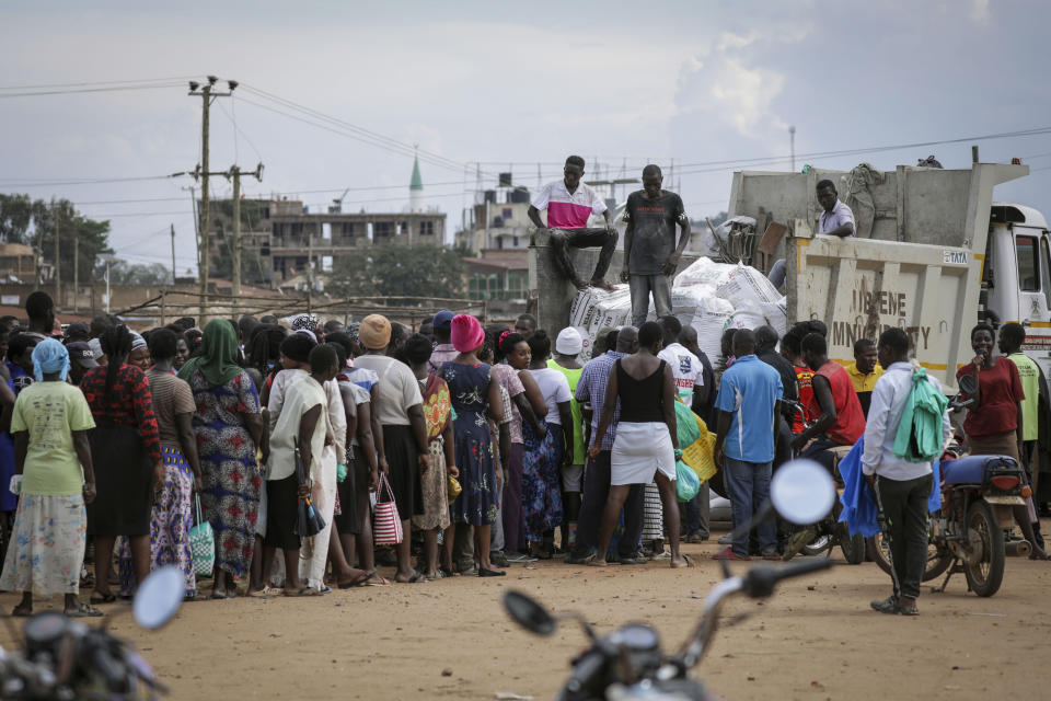 People await a food distribution from a truck aimed to help those affected by the travel restrictions imposed in an attempt to limit the spread of Ebola, at a football pitch in Mubende, Uganda Tuesday, Nov. 1, 2022. Ugandan health officials say they have controlled the spread of a strain of Ebola that has no proven vaccine, but there are pockets of resistance to health measures among some in rural communities where illiteracy is high and restrictions on movement and business activity have left many bitter. (AP Photo/Hajarah Nalwadda)