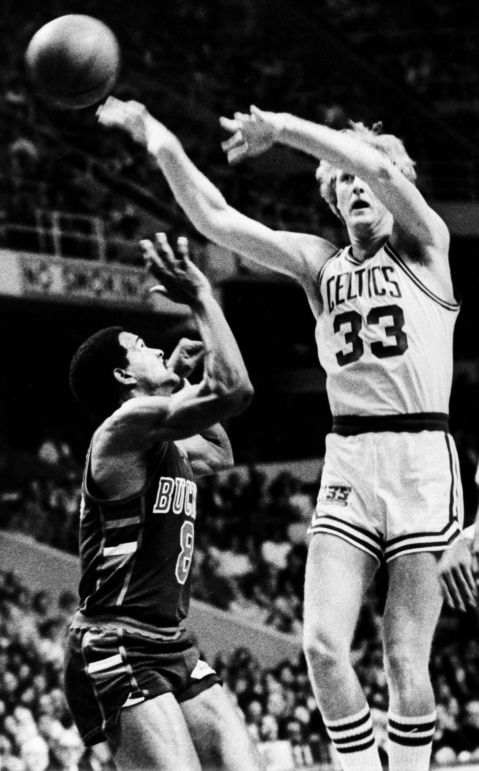 FILE - Boston Celtics Larry Bird, right, passes off to teammate as Milwaukee Bucks Marques Johnson steps in to block his path during NBA action in Boston, Nov. 7, 1980. (AP Photo/John Martell, File)