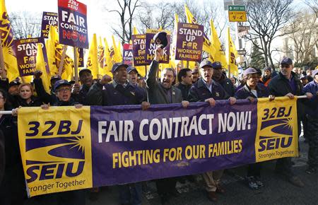 Hector Figueroa (center raising hat), president local chapter 32BJ of the Service Employees International Union (SEIU), leads a march in support of a new contract for apartment building workers in New York City, April 2, 2014. REUTERS/Mike Segar