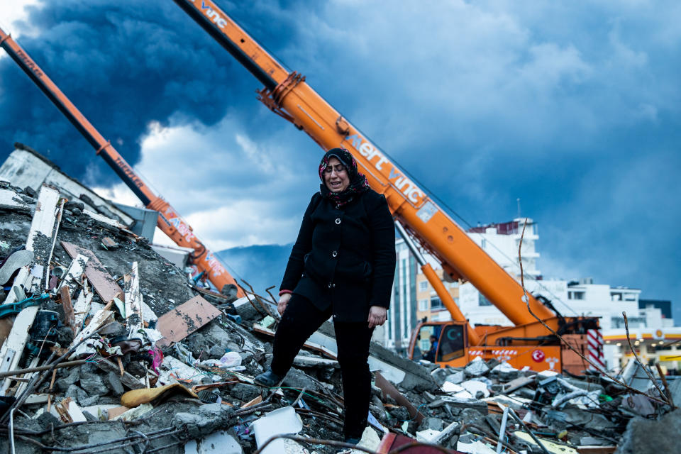 A woman waits for news of her loved ones, believed to be trapped under a collapsed building in Iskenderun, Turkey