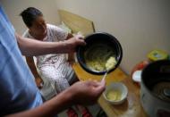 Liu serves breakfast for his wife, Wang, in their room at the accommodation where some patients and their family members stay while seeking medical treatments in Beijing, China, June 23, 2016. REUTERS/Kim Kyung-Hoon