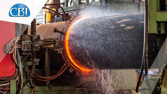 Pipeline manufacturing facility showing red-hot metal cooled with water.