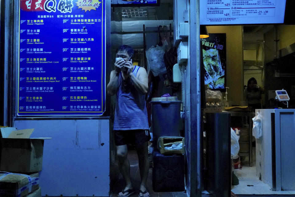 A local resident covers his mouth from tear gas deployed as police confront protesters during a protest in Hong Kong on Saturday, Sept. 21, 2019. Protesters in Hong Kong burned a Chinese flag and police fired pepper spray Saturday in renewed clashes over grievances by the anti-government demonstrators. (AP Photo/Vincent Yu)